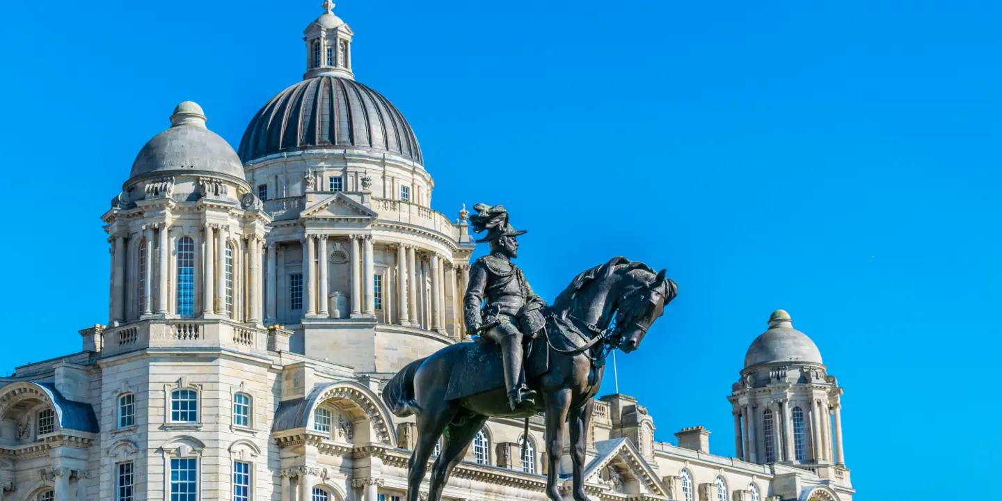 Statue of a man on horseback in front of a building.
