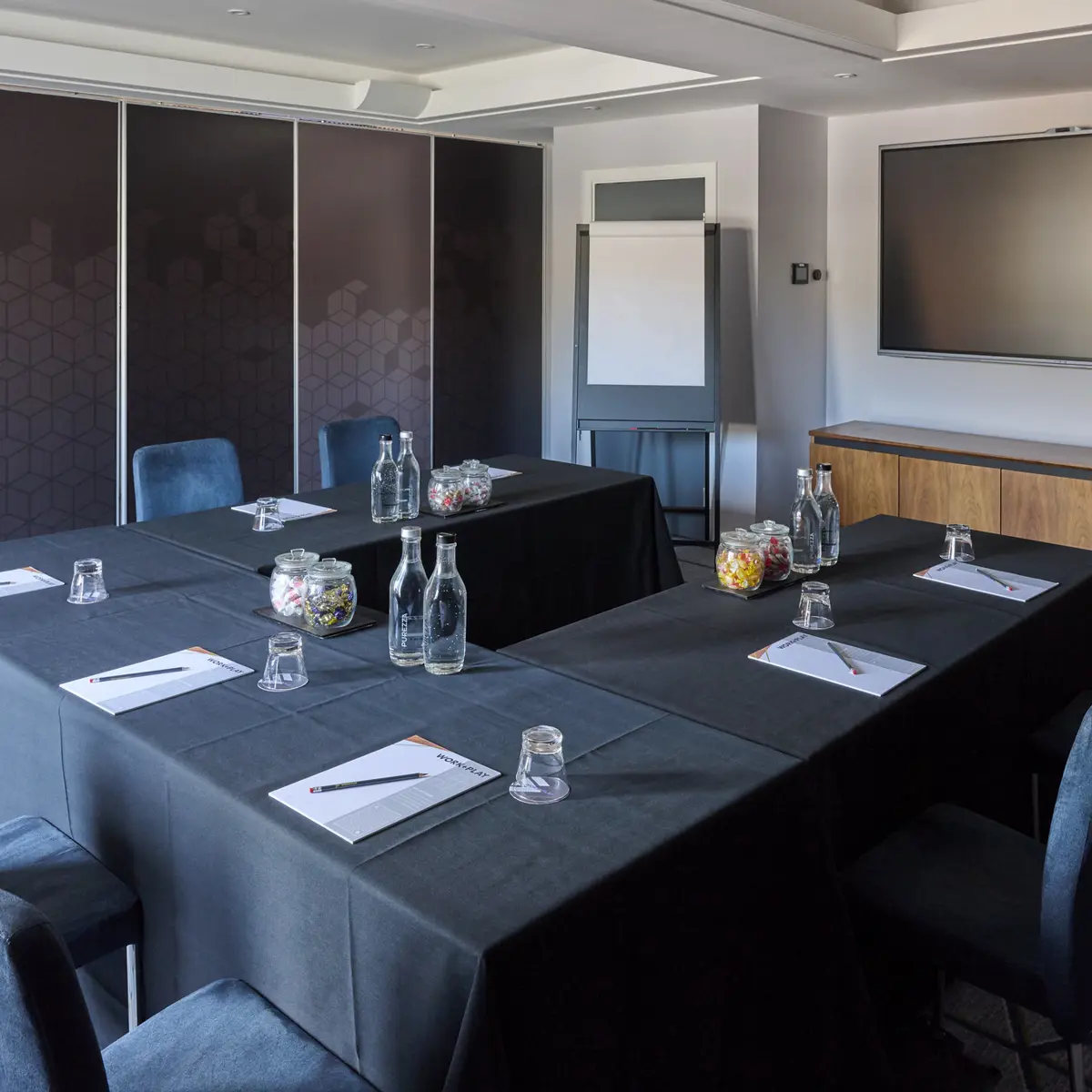 Conference room featuring blue chairs and a flat-screen TV.